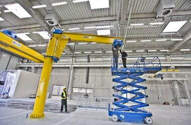 Montage d'un pont roulant sur une grue pivotante autonome dans un hall de production de la société Rolls-Royce en Pologne