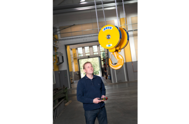 Un employé heureux conduit une grue ABUS dans un hall de production en Suède