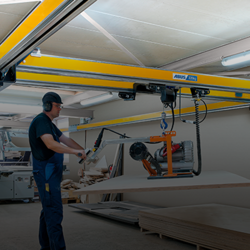 Un employé utilise un pont bipoutre ZHB-X et effectue le levage d'une charge à l'aide d'un palan à chaîne dans un atelier.