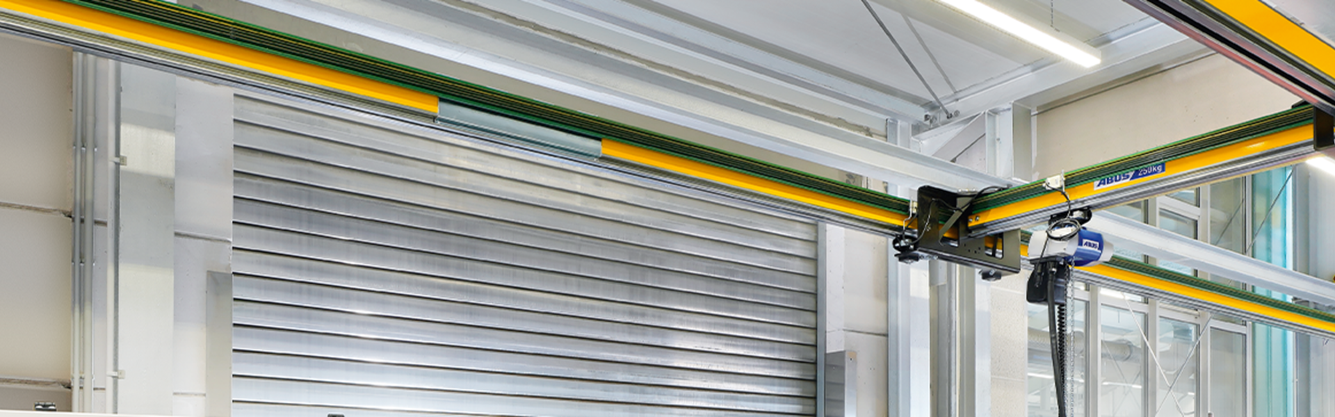 Pont monopoutre EHB-X rehaussé dans un hangar industriel, pour un levage précis et un transport efficace des matériaux.